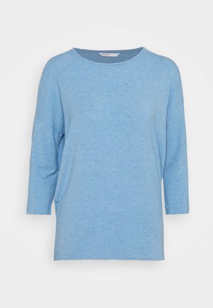 Kék, könnyű felső, puha anyagból készült. Kerek nyakkivágással és háromnegyedes ujjakkal rendelkezik. Lazán, kényelmesen illeszkedő fazon.