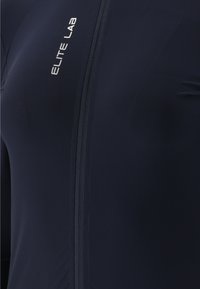 Jersey da ciclismo blu navy realizzato in tessuto liscio e elasticizzato. Presenta una cerniera frontale e il testo "ELITE LAB" in argento riflettente sul petto.