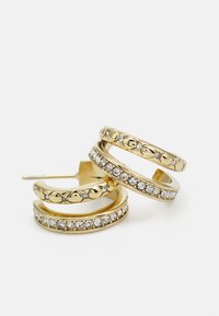 Boucles d'oreilles en or en forme de créole avec une finition lisse et des strass clairs intégrés, ornées d'un motif décoratif sur la partie supérieure.