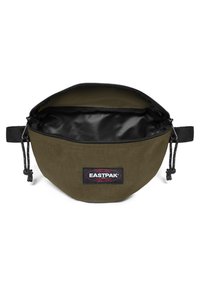 Olivgrön tygpåse med ett svart dragkedjeöppning, med en slät inredning. Inkluderar en Eastpak-logotypklistermärke på framsidan.