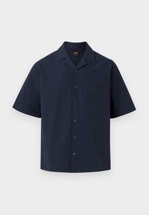 Camicia blu navy scuro a maniche corte con bottoni, colletto appuntito e taschino sul petto su sfondo chiaro e uniforme.