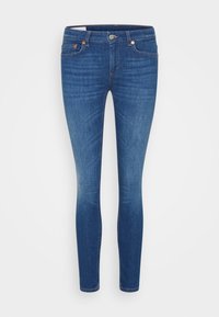 Tight jeans i mörkblå denim, med midja i normalhöjd, fem fickor, koppardetaljer och subtil uttoning ner längs benen.
