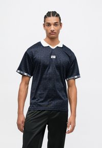 Polo shirt navy cu mânecă scurtă, cu guler alb, având un model repetat cu logo-ul "R". Fabricat dintr-un material neted, cu o croială lejeră și accente cu marcă.