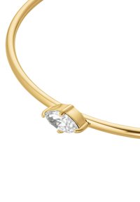 Brazalete de bangle en tono dorado que presenta un cristal transparente en forma de pera, diseñado de manera elegante y pulida, con una banda circular suave.