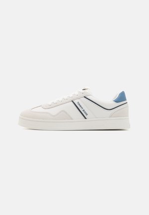 White and light gray sneakers with suede and leather materials, featuring a blue accent, contrasting stripes, and a textured sole.