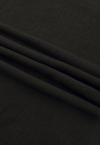 Tissu noir à texture douce, présenté avec trois plis horizontaux prononcés sur un fond lisse.