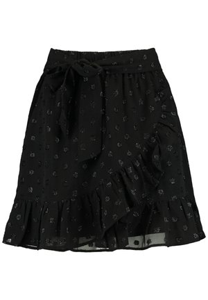Jupe noire longueur genou avec motif de points scintillants, ourlet à volants, style portefeuille et nœud noué à la taille sur fond blanc.