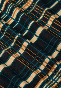 Kangas yang menampilkan pola kotak-kotak dengan garis bergantian teal, emas, dan krim di latar belakang navy gelap, menonjolkan tekstur halus dan warna.