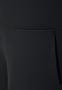 Svarta träningsleggings med ett mjukt, stretchigt tyg, subtila söm detaljer och ett säker midjeband för komfort och passform.