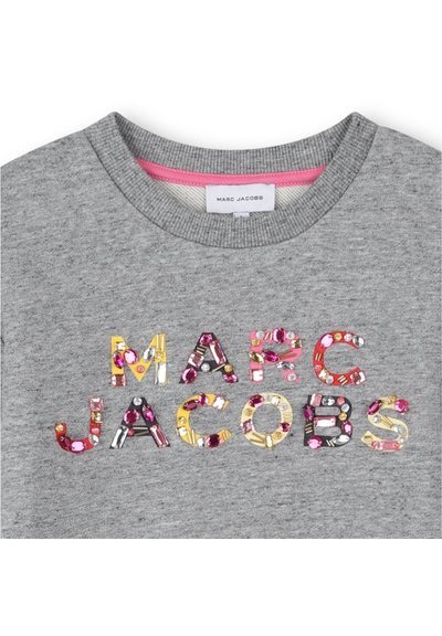 Sivá mikina s viacfarebnými ozdobnými písmenami, ktoré tvoria nápis "MARC JACOBS." Výstrih má ružový akcent na žebrovanom golieri.