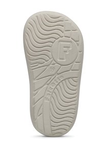 Witte rubberen zool van een schoen met gestructureerde golfpatronen en een cirkelvormig logo met de letter "F." Markeringen zijn "19" en "Falcotto."