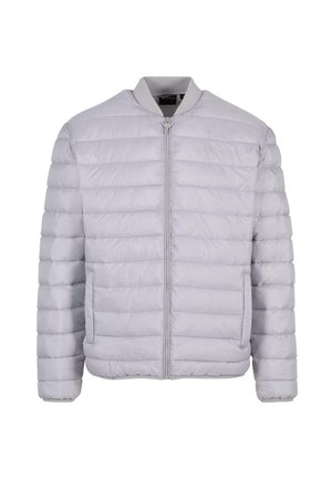 Svetlo siva puhovka s kvadratnim dizajnom, zadrga spredaj, rebrastim ovratnikom in dvema stranskima žepoma. Narejena iz gladkega, lahkega materiala.