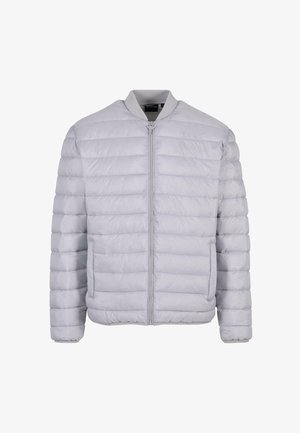 Svetlo siva puhovka s kvadratnim dizajnom, zadrga spredaj, rebrastim ovratnikom in dvema stranskima žepoma. Narejena iz gladkega, lahkega materiala.