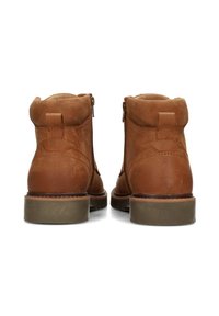 Botas de cuero marrón hasta el tobillo con un acabado liso, que cuentan con una cremallera lateral, puntera redondeada y una suela de goma baja y texturizada.