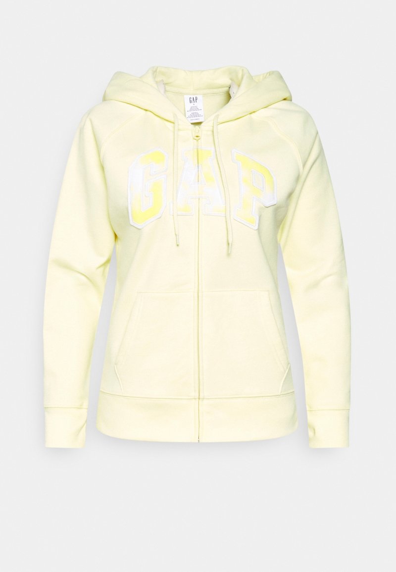 Haut à capuche zippé jaune avec cordon de serrage, portant le logo "GAP" en blanc et jaune clair. Fabriqué en tissu doux avec deux poches avant.