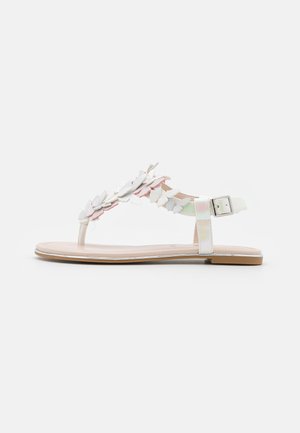 Sandalias tipo tanga blancas con suela plana, que presentan un diseño floral en colores pastel y una correa ajustable en el tobillo con herrajes plateados.