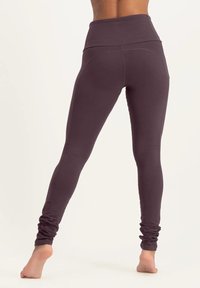 Braune hoch geschnittene Leggings aus dehnbarem Material, mit einer engen Passform, Kontur-Nähten und gerafften Details am Knöchel.