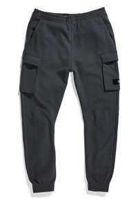 Pantalones jogger gris oscuro hechos de un material suave. Incluyen bolsillos laterales, puños elásticos y un bolsillo estilo cargo en el muslo.