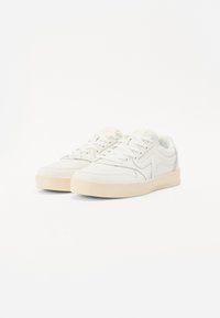 White athletic sneakers with a smooth texture, lace-up design, and light beige rubber sole. Features subtle stitching and minimal branding.