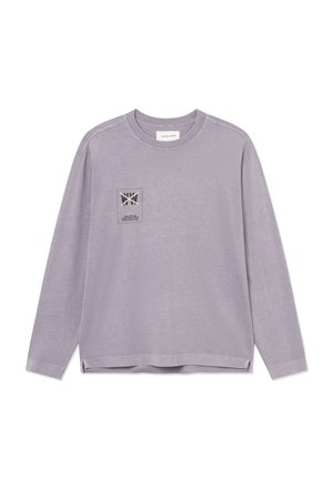 Lila shirt met lange mouwen en een ronde hals, voorzien van een klein bedrukt logopatchje op de linkerborst met tekst- en grafische elementen.