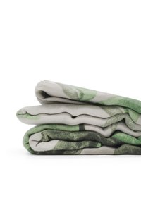Coperta piegata con un morbido mix di tessuti, decorata con un motivo di foglie verdi su uno sfondo chiaro, che presenta una superficie texture.