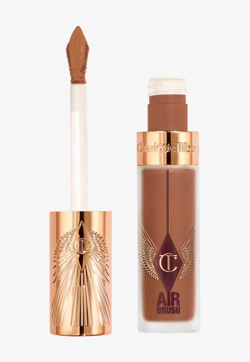 Fond de teint liquide dans un flacon en verre transparent avec des accents dorés et bordeaux foncé. Comprend un applicateur type doe-foot dans un tube doré. Teinte : brun chaud.