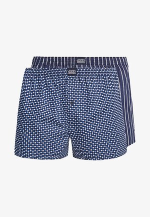 Boxers en azul marino, con un patrón de diamantes en un lado y rayas verticales en el otro. Hechos de tela transpirable con una cintura cómoda.