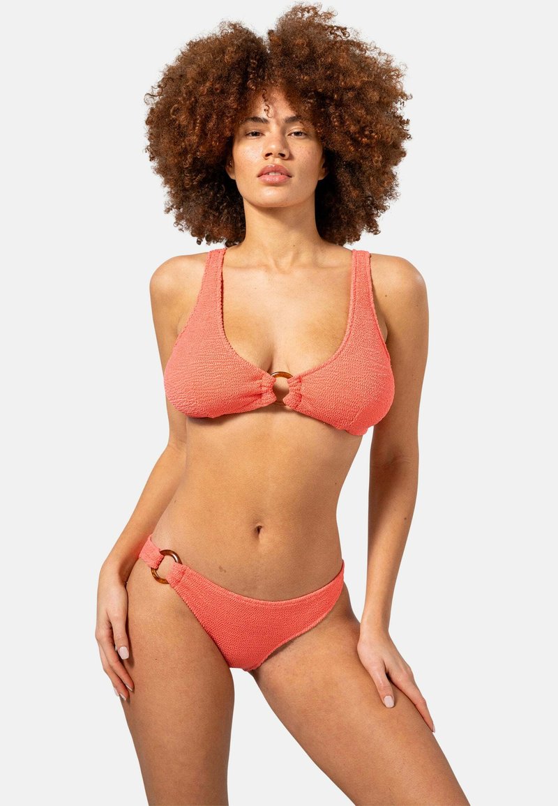 Korallfärgad bikini med textur, bestående av en triangulär bralette med en accent i form av en främre slinga och matchande låga bottoms med sidoringar.
