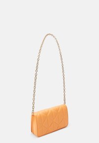Pomarańczowa pikowana torba o prostokątnym kształcie, z paskiem z złotego łańcuszka i tłoczonym wzorem diamentowym na przodzie.
