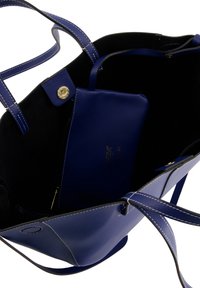 Blue leather tote bag with contrasting white stitching, open interior, and a matching zippered pouch inside. Featuring long, flat handles.