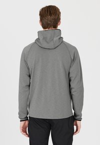 Grå pullover hoodie med snøre i hætten og lange ærmer, der har en glat overflade og kontrasterende sorte detaljer ved manchetterne.