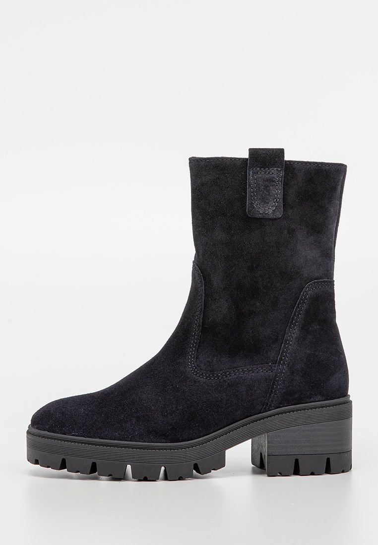 Stivale alla caviglia in suede nero con punta rotonda, design slip-on, estetica tessurizzata e suola in gomma robusta con un leggero tacco.