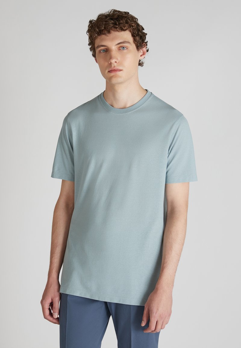 Helles blaues T-Shirt mit kurzen Ärmeln aus weichem Stoff, mit Rundhalsausschnitt und lockerer Passform. Glatte Textur ohne sichtbare Muster.