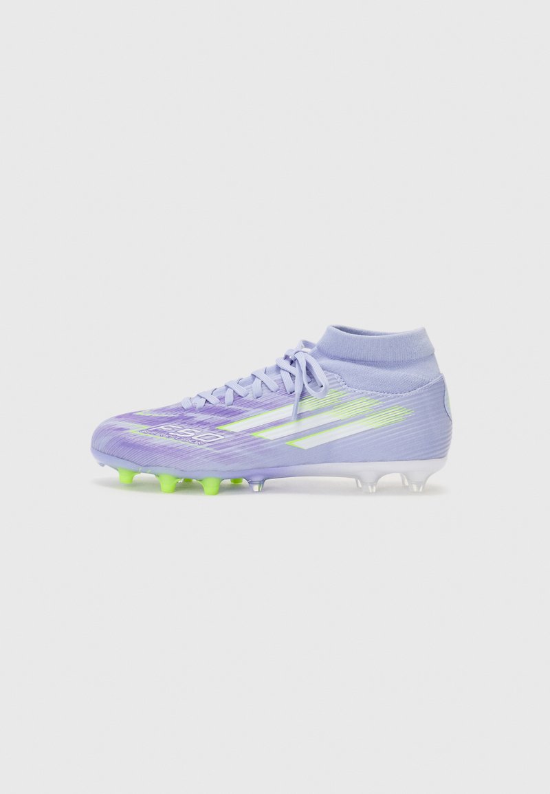 Purple soccer cleat with green studs, sock-like collar, textured upper, three white accent stripes, and reinforced toe area.
