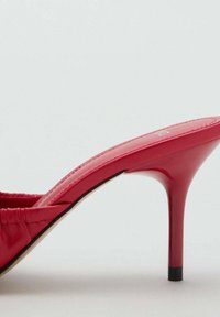 Sandale à talon haut rouge avec une finition en cuir verni brillant, design ouvert à l'avant et talon aiguille fin. Présente un tissu froncé sur le dessus.