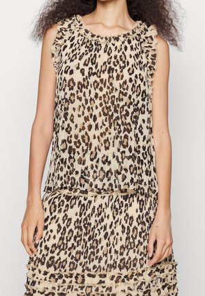 Haut et jupe plissés sans manches avec imprimé léopard beige et marron foncé, bords à volants, portés par une personne aux cheveux bouclés.