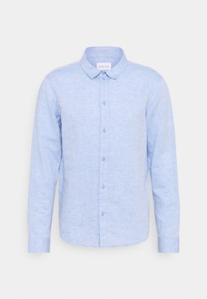 Camicia a maniche lunghe di lino di colore azzurro chiaro con colletto abbottonato, dotata di placca con bottoni frontali e polsini con un bottone.