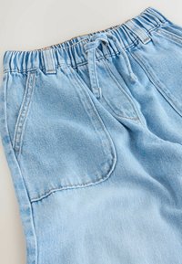 Svijetloplave traper kratke hlače imaju elastični pojas sa špagom, prednje džepove i mekan, teksturirani materijal s diskretnim uskim prugama.