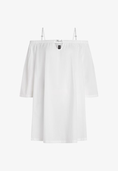 Robe blanche décolletée avec des manches courtes, fabriquée en tissu léger. Elle présente un col rond et un design ample et fluide.
