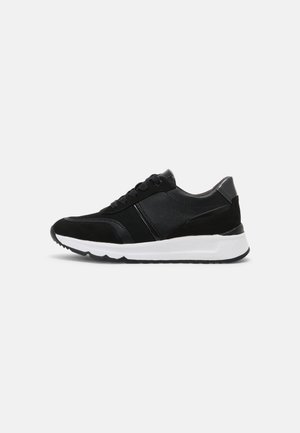 Sort lav-snit sneakers med snørebånd foran, overdel i blandet materiale og tyk hvid sål, vist fra siden på en ensfarvet baggrund.