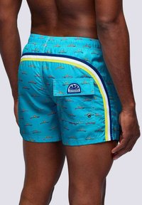 Shorts da bagno da uomo in tessuto turchese brillante con una piccola stampa di barche. Presentano una tasca posteriore, strisce laterali bianche e blu navy a contrasto e un logo.