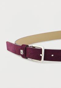 Burgunderfarbener Wildledergürtel mit einer silbernen Metallschnalle und Logo-Akzent. Verfügt über ein glattes Innenfutter und fünf verstellbare Löcher zur Größenanpassung.
