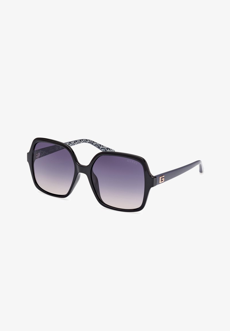 Ochelari de soare negri, supradimensionați, cu lentile gradient violet, având un mâner interior cu model și un accent de logo aurit pe templu.
