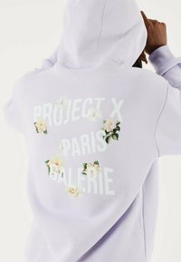 Sudadera lavanda con el texto blanco "PROJECT X PARIS GALERIE" adornado con gráficos florales, tejido texturizado y capucha.