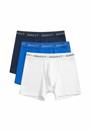 Tre boxer da uomo impilati in bianco, blu e blu navy, ciascuno con una fascia in vita con il marchio "GANT" in testo a contrasto.