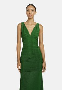 Grünes, glitzerndes, ärmelloses Abendkleid mit tiefem V-Ausschnitt, gerafftem Oberteil und taillierter Silhouette, die bis zum Boden reicht.