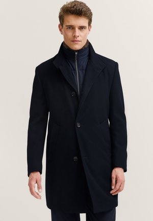 Marineblauer Wollmantel mit Reverskragen, sechs Knöpfen und zwei Seitentaschen. Verfügt über eine gefütterte Innenschicht mit Reißverschluss für zusätzliche Wärme.