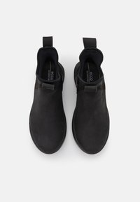 Chaussons noirs en cuir lisse, à bout arrondi, avec des panneaux latéraux élastiques et des languettes pour un enfilage facile. Conçus pour le confort.