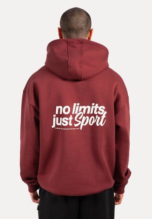 Bordeauxfarbener Kapuzenpullover mit großem weißem Grafiktext "no limits just Sport" auf dem Rücken, ausgestattet mit einer Kordelzugkapuze und langen Ärmeln.