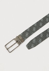 Grijze lederen riem met herhalend monogrampatroon en zilverkleurige rechthoekige metalen gesp op witte achtergrond.